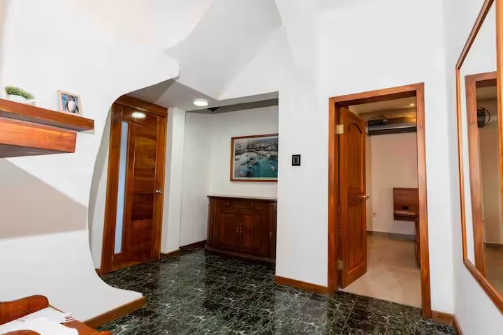 Marble hallway with wood doors and local artwork at GPS Villa, Puerto Ayora