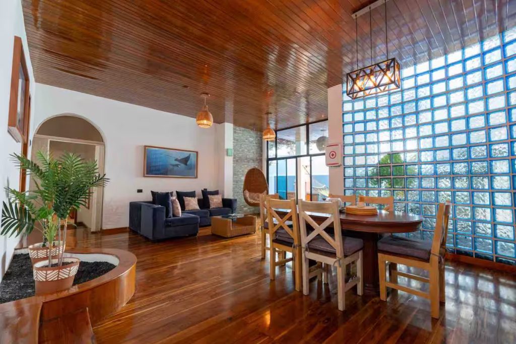 Open dining and living room with glass-block wall at GPS Villa, Puerto Ayora