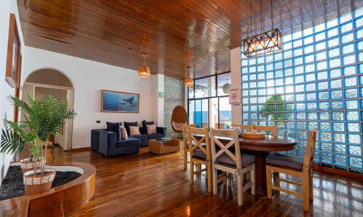 Open dining and living room with glass-block wall at GPS Villa, Puerto Ayora