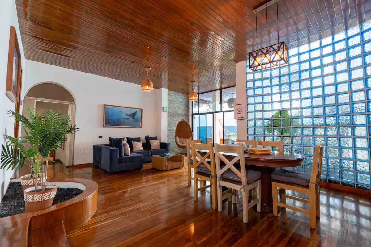 Living room and dining table at GPS Villa, with the bay beyond the glass